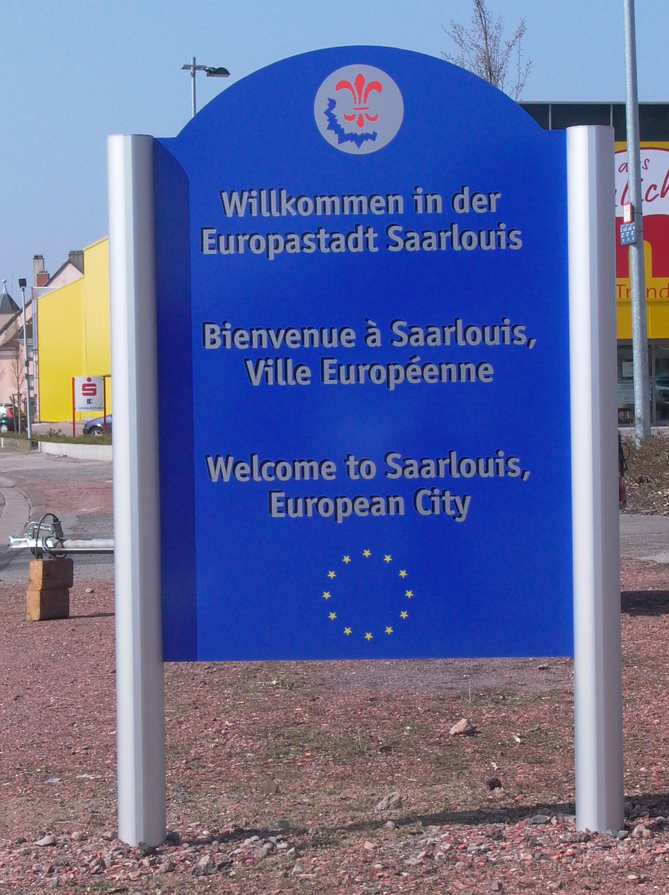 Ortseingangsschild auf Rohrpfosten